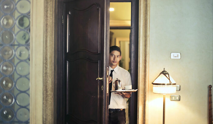 Hotel employee holding cup of coffee