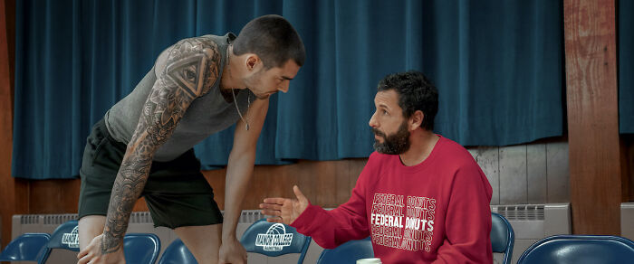 Two actors in a conversation on a basketball court set, highlighting top highest-paid actors in a casual scene.