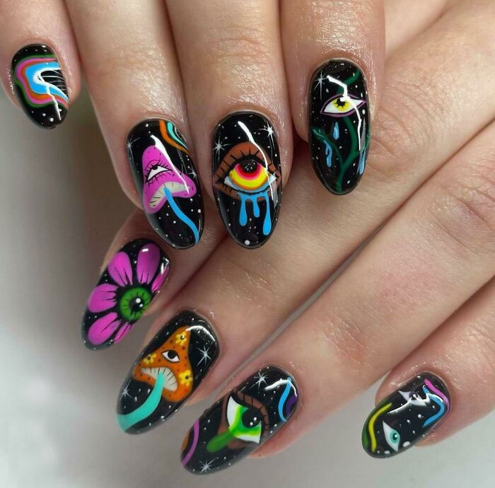 Colorful psychedelic nail art with eyes and mushrooms on black background.