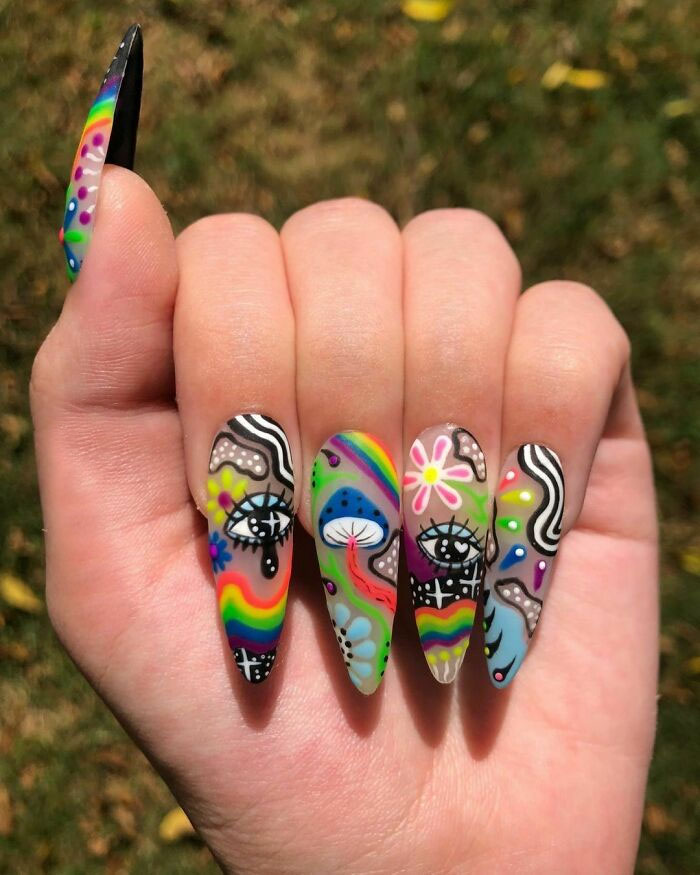 Colorful nail art with psychedelic designs and floral patterns in a creative manicure.