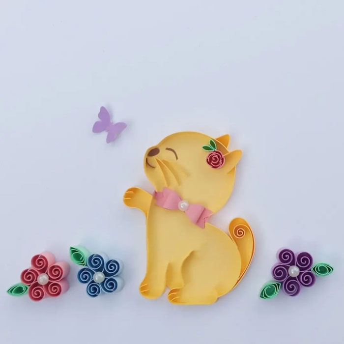 a yellow kitten made out of a paper with flowers and butterfly