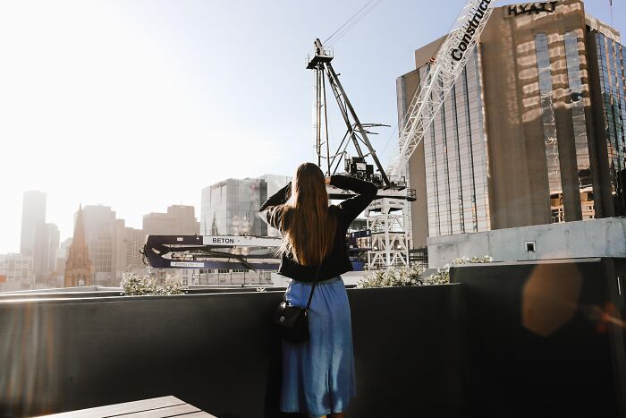 Woman Looking At The Roof Crane In The Back 