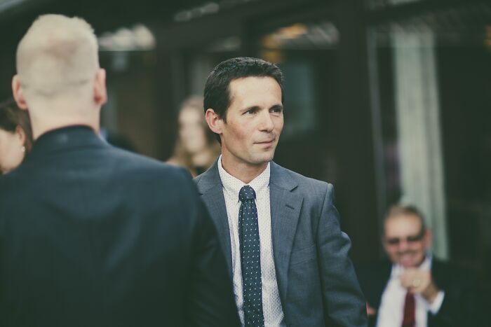 Man in a suit at a social event, highlighting myths believed true but are actually false.