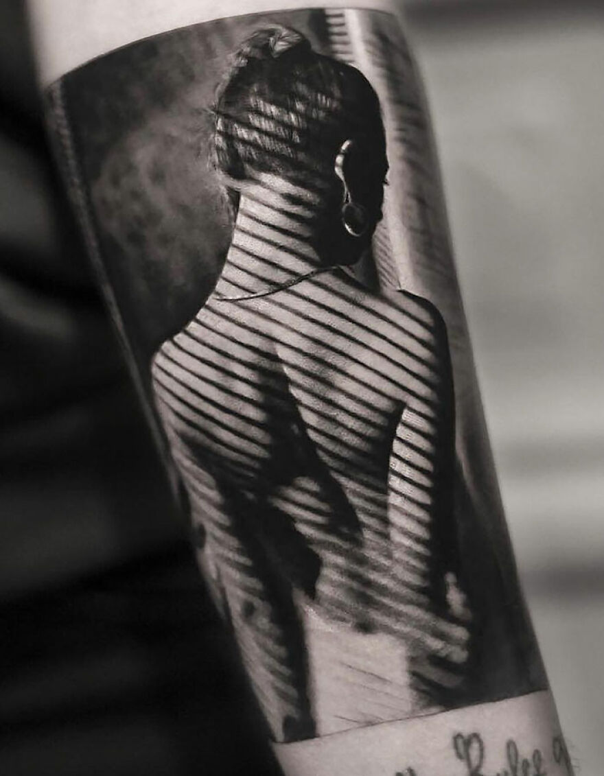 Realistic tattoo of a young woman's back with striped shadows, showcasing intricate detailing.