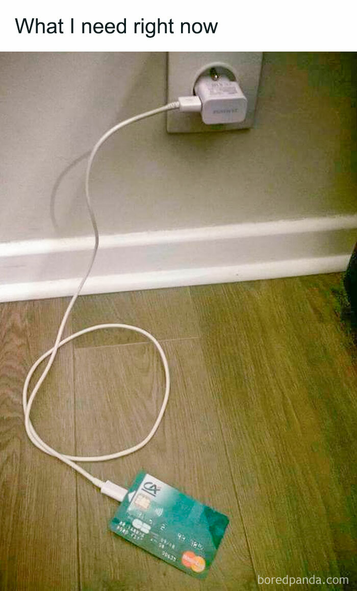 Credit card plugged into a wall charger, humorously illustrating money needs.