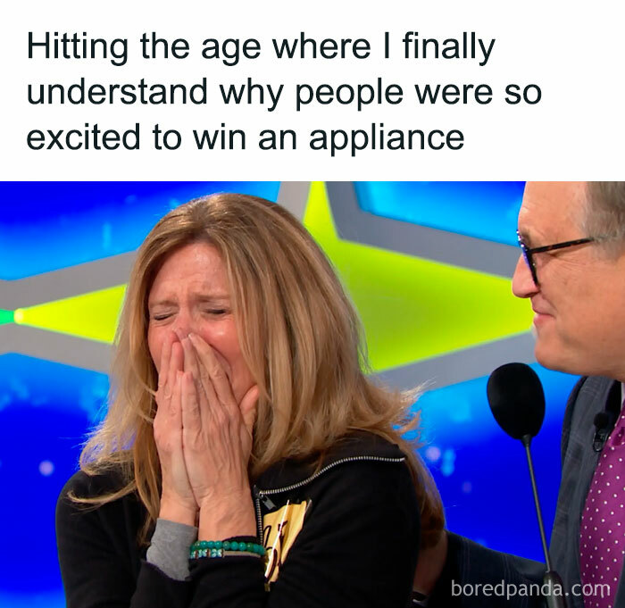 A woman laughing on a game show about money, realizing the excitement of winning an appliance.