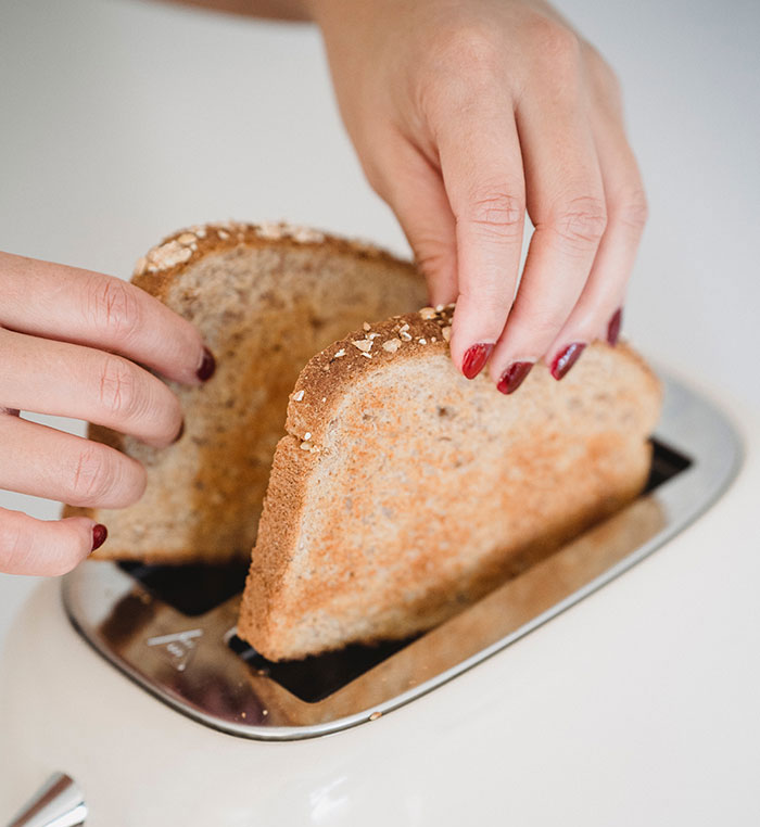  Female Hands Putting Bread to Toaster