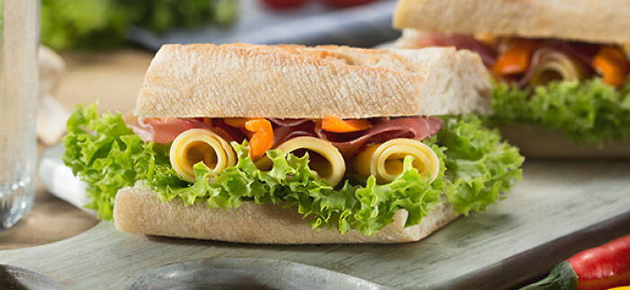  sandwich with lettuce and cheese served on chopping board