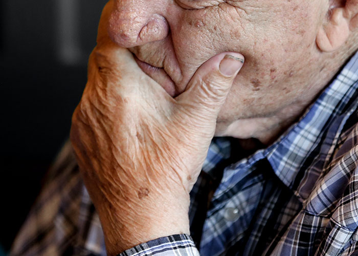 Elderly man in plaid shirt deep in thought, illustrating the theme of scientific fear and chilling realities.