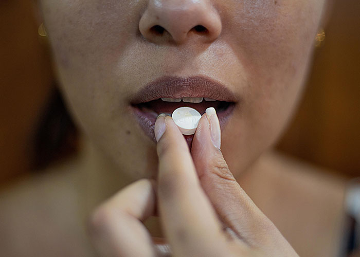 Person taking a pill, highlighting the chilling reality of scientific discoveries proven to be real.