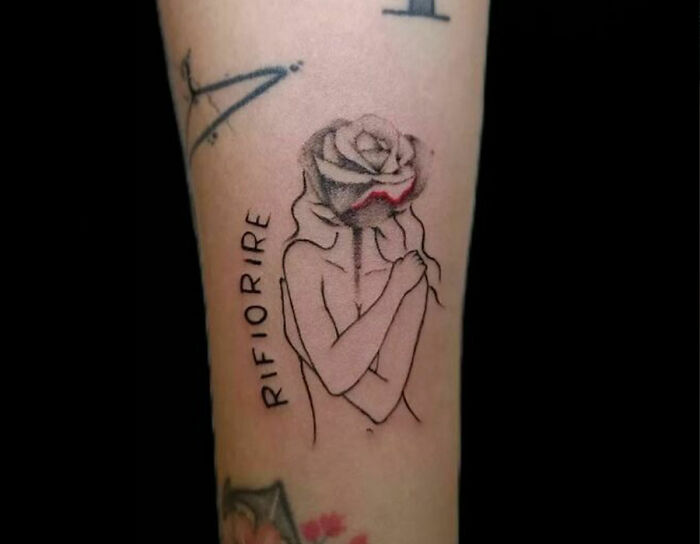 Self-love tattoo with an abstract figure embracing itself, featuring a rose and the word "RIFIORIRE."
