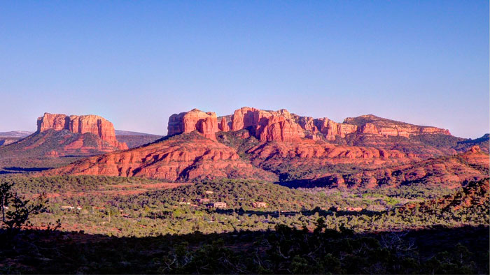 Couple of building in a forest near red mountains 