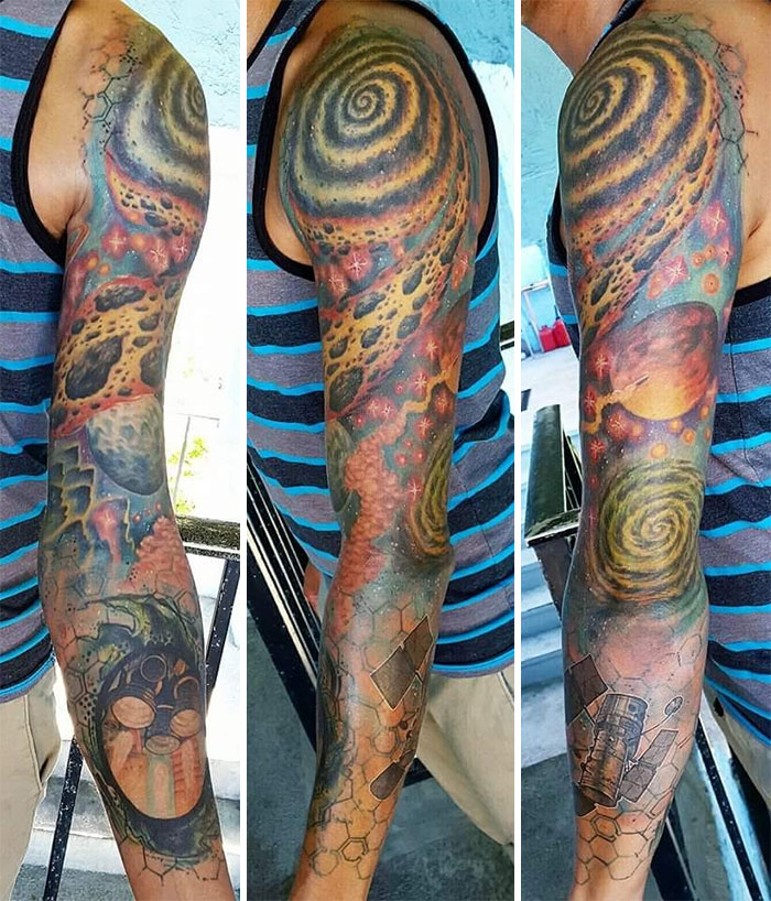 Arm sleeve with cool space tattoos showing galaxies and planets in vibrant colors.