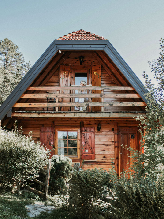 Woman in wooden house balcony