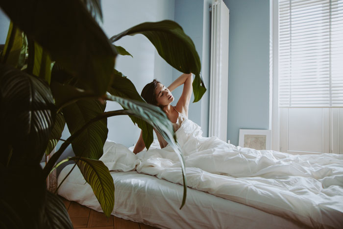 A woman is waking up in her bed