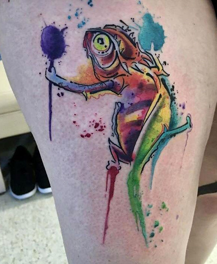 Colorful watercolor tattoo of a chameleon on skin, blending vibrant hues for inkspiration.