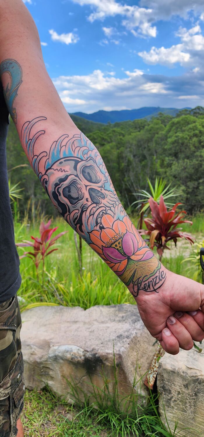 Colorful skull and lotus tattoo on forearm, showcasing cool tattoo design.