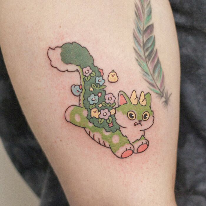 Adorable animal-themed tattoo of a whimsical creature with floral design on an arm.