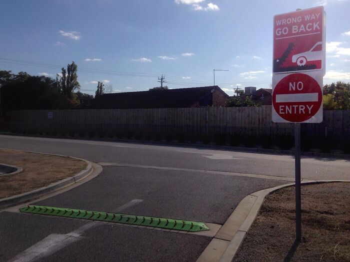Wrong way warning signs and spikes on a road, showcasing innovative gadgets from cities worldwide.