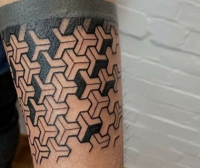 Geometric tattoo with intricate black pattern on forearm.