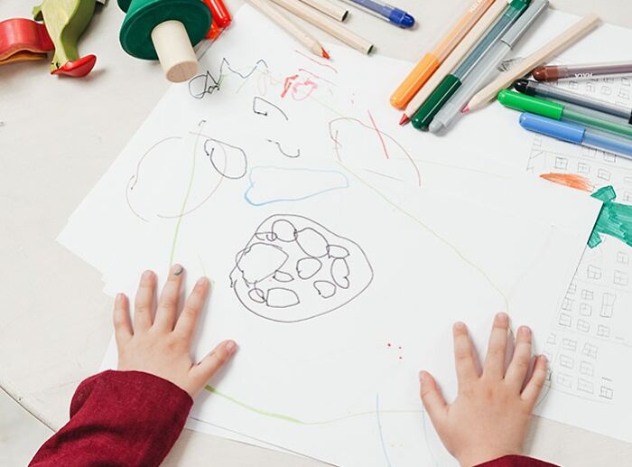 Kid on white table painting