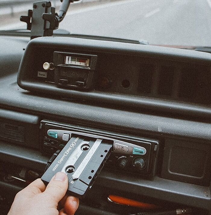 Person inserting cassette tape on cassette player