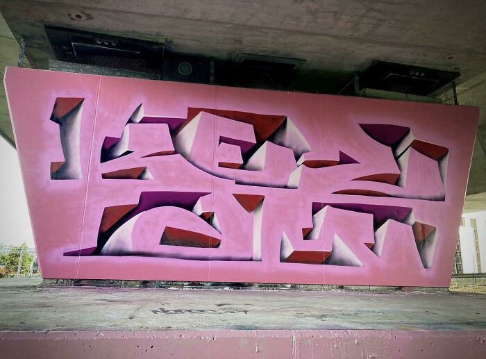 Pink abstract graffiti art on an urban wall showcasing creative graffiti art that transformed a blank surface.