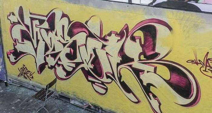 Colorful graffiti art in creative style painted on a blank yellow wall showcasing urban artistic expression.