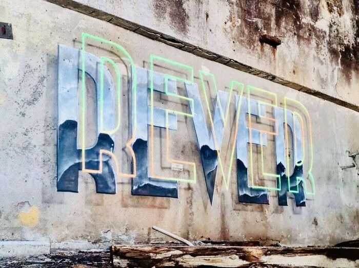 Graffiti art spelling "REVER" with mountain and sky design, creatively transforming a blank concrete wall.
