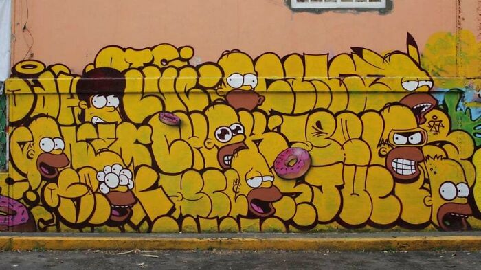 Colorful graffiti art featuring cartoon faces and donuts, transforming a blank wall with creative street art designs.