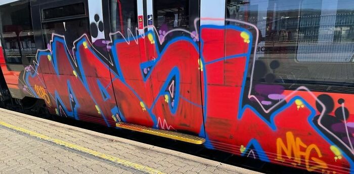 Colorful graffiti art covers the side of a train, showcasing creative street art that transforms blank surfaces into vibrant displays.