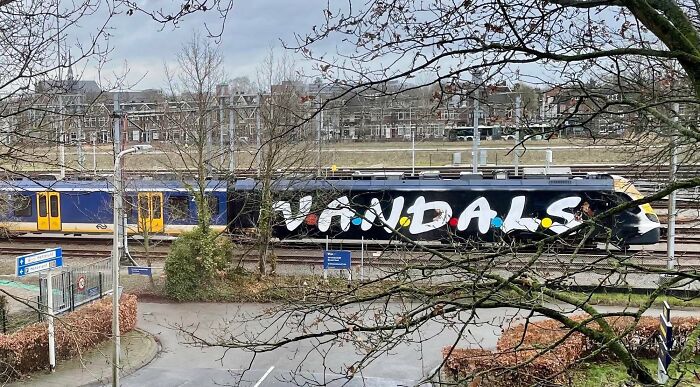 Graffiti art with bold lettering on a train car, showcasing creative street art transforming urban spaces.