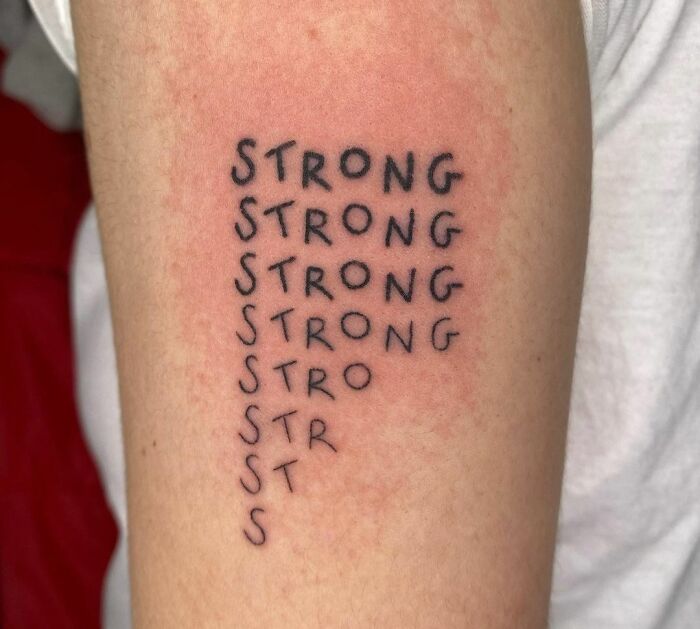Word tattoo on arm featuring the repeated word "STRONG" in a descending pattern.