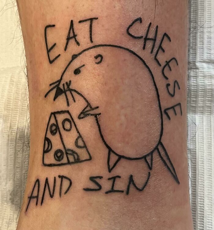 Tattoo of a cartoon rat with cheese and the words "Eat Cheese and Sin" on skin, embodying a playful theme.