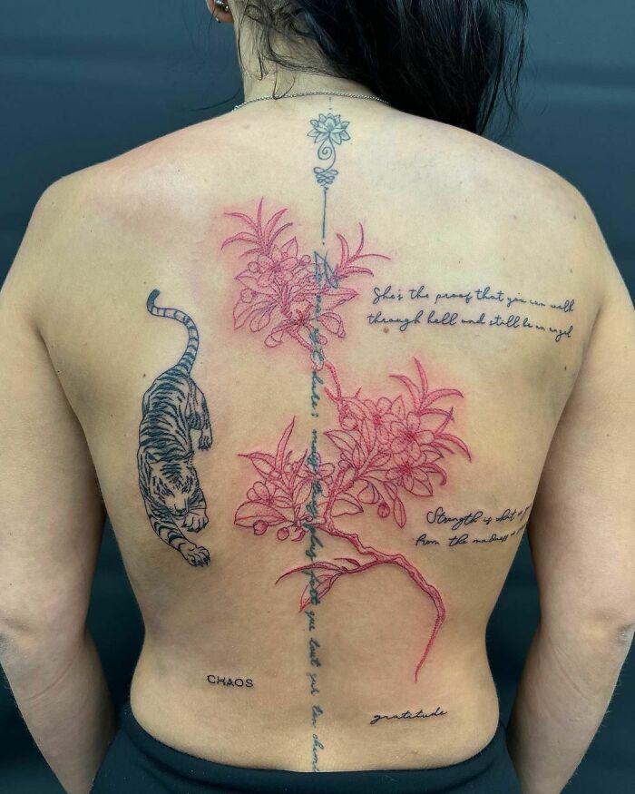 Back tattoo featuring red ink floral design and a black ink tiger, showcasing unique red ink tattoo ideas.
