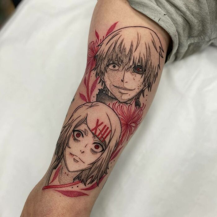 Red ink tattoo on forearm featuring two stylized faces with floral accents.