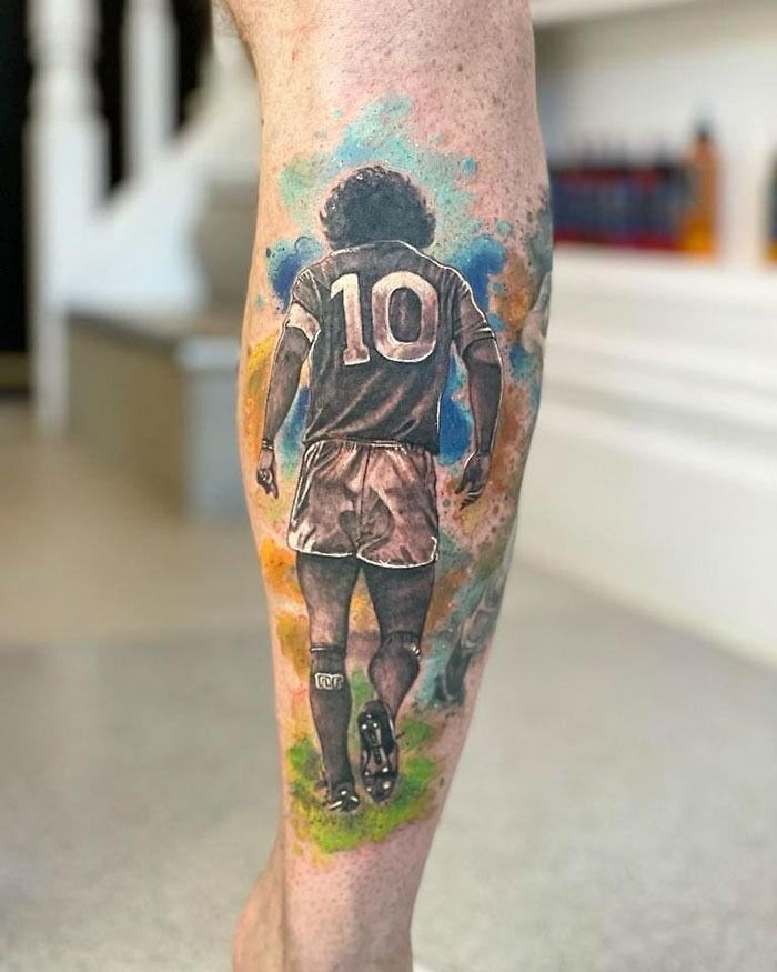 Colorful soccer player design on lower leg tattoo.