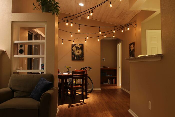 Cozy home decoration with string lights and neutral tones in a dining area, enhancing a warm ambiance.