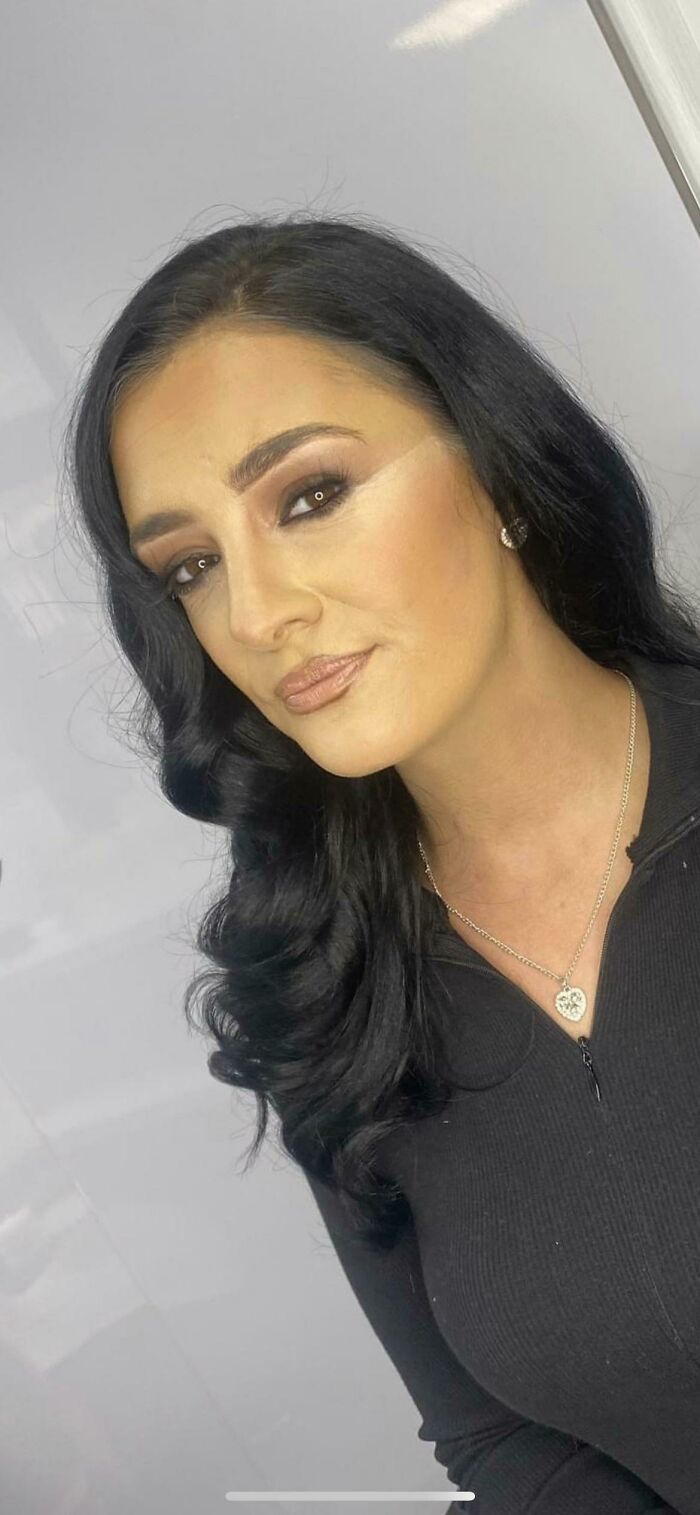 Makeup artist mishap with uneven contour and heavy eyeshadow application.