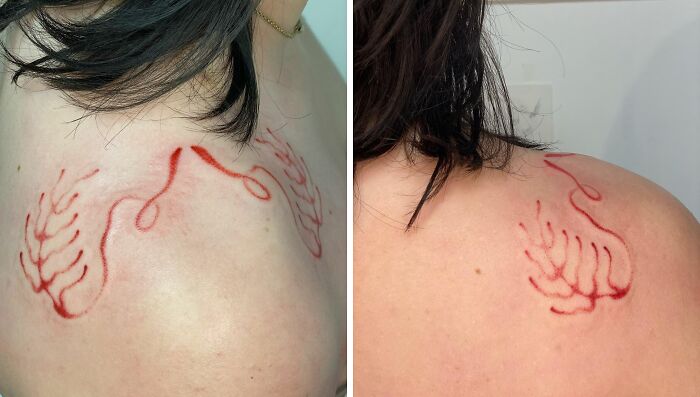Red ink tattoo with abstract design on woman's shoulder.