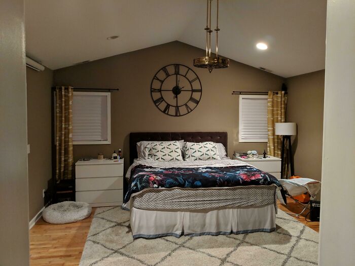 Modern bedroom with stylish decor, featuring a large wall clock and cozy bed, showcasing home decoration ideas.