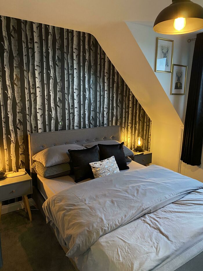 Cozy bedroom with birch tree wallpaper, grey bedding, and stylish lighting for creative inspiration.