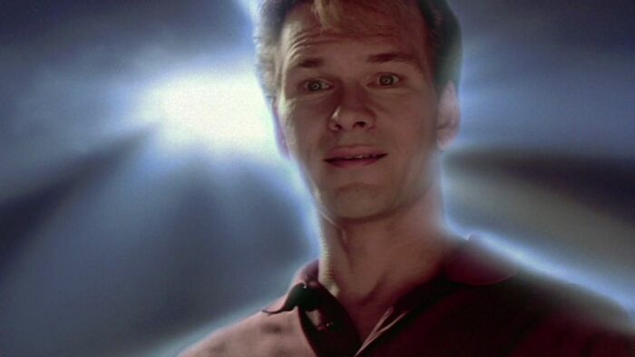 Sam is smiling with the light behind him 