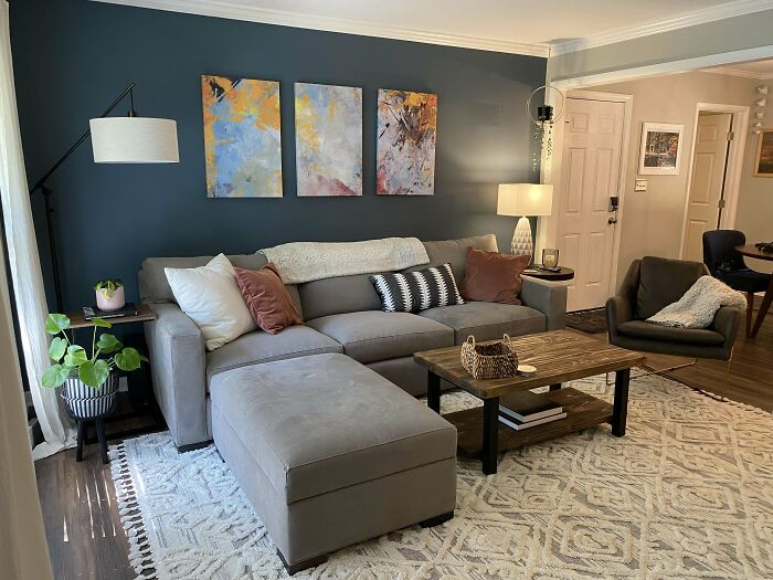 Cozy home decoration with a grey sectional sofa, abstract art, and stylish accents in a modern living room.