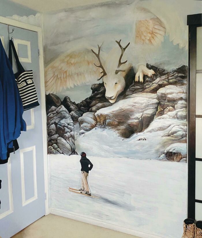 Creative decoration idea with a mural of a skier facing a mythical creature with antlers and wings.