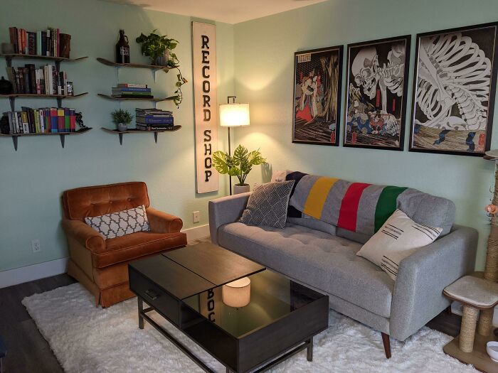 Cozy living room with a colorful sofa, artwork, and bookshelves for home decoration ideas.