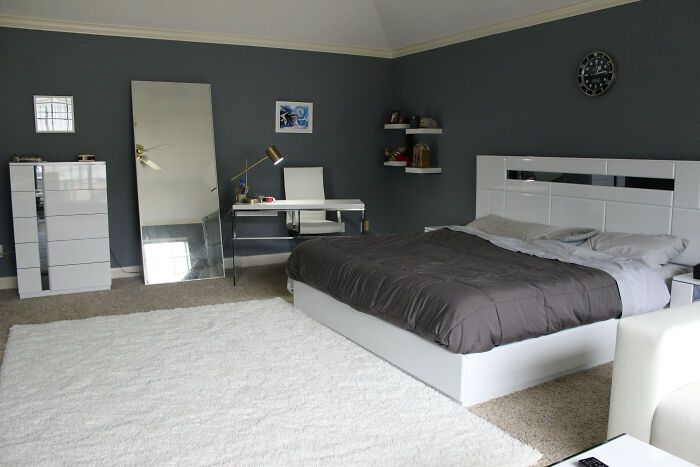 Modern bedroom with gray walls and white furniture, showcasing stylish home decoration ideas.