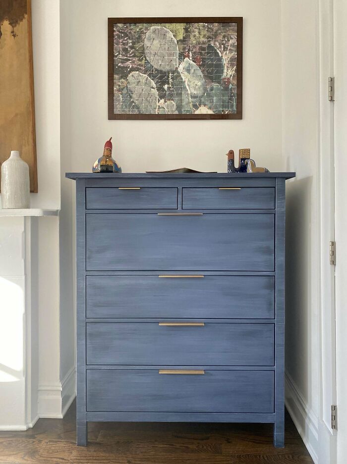 Blue dresser under a cactus-themed wall art, offering creative decoration inspiration.