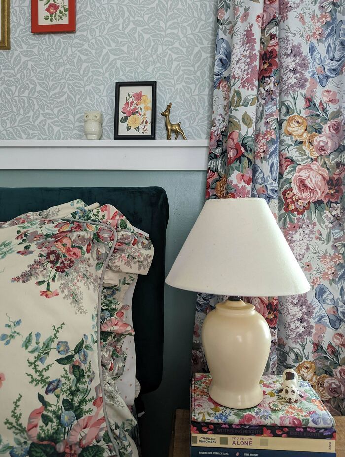 Creative inspiration with floral bedding, a table lamp, and book stack in a cozy decor setting.
