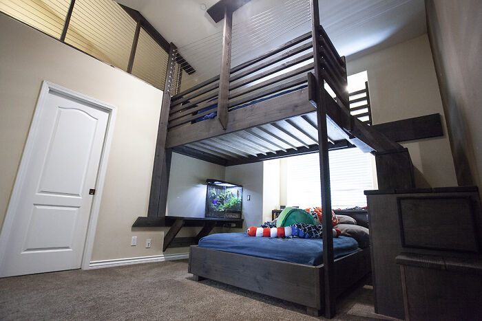Loft bed with aquarium underneath in modern home decor setup.